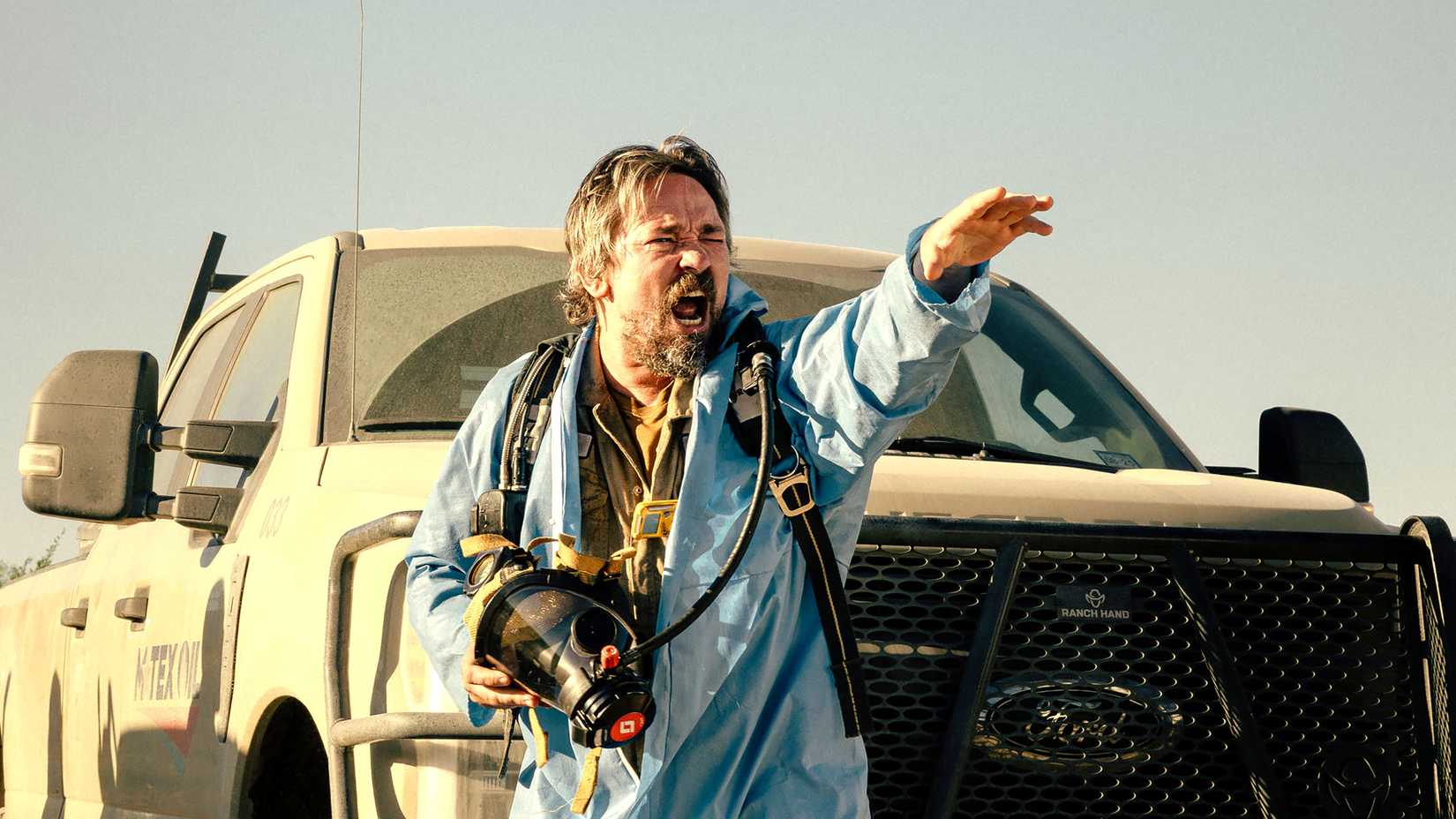 James Jordans Dale schreit und sieht besorgt aus, während er eine Gasmask in Landman, Staffel 2 hält