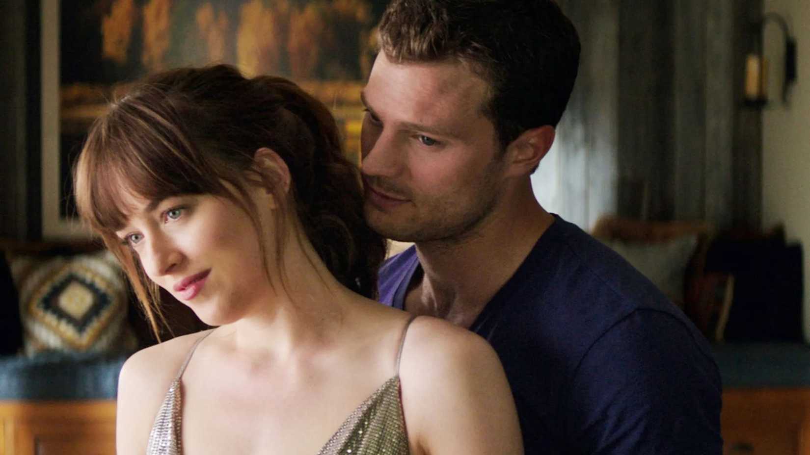 Jamie Dornan como Christian Grey segurando Dakota Johnson como Ana em Cinquenta Tons de Liberdade