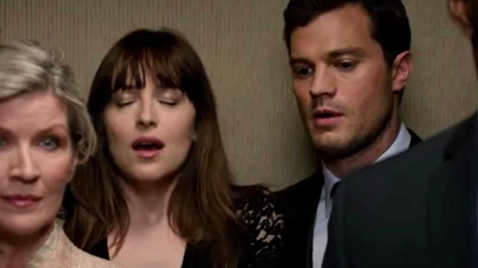 Jamie Dornan como Christian Grey em um elevador com Dakota Johnson como Ana em Cinquenta Tons Mais Escuros