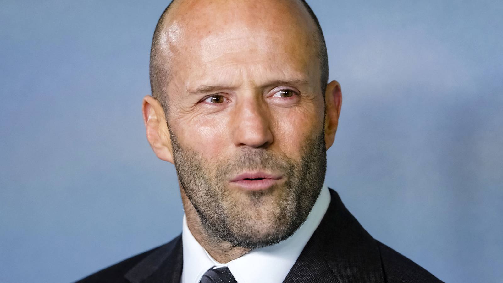 Jason Statham sieht fasziniert auf einem roten Teppich aus