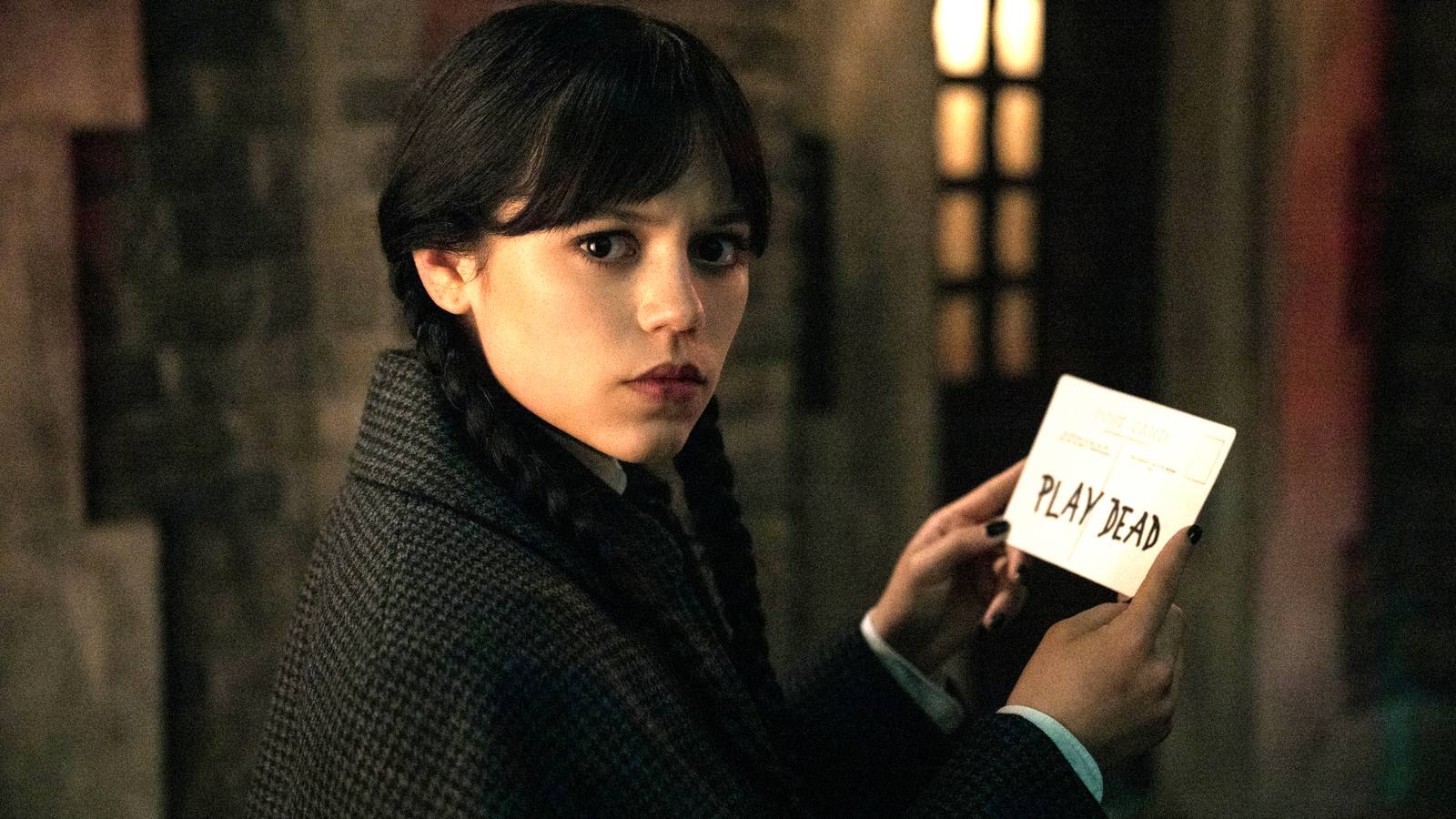 El miércoles de Jenna Ortega mirando con curiosidad por encima del hombro mientras sostiene una nota en la temporada 2 del miércoles