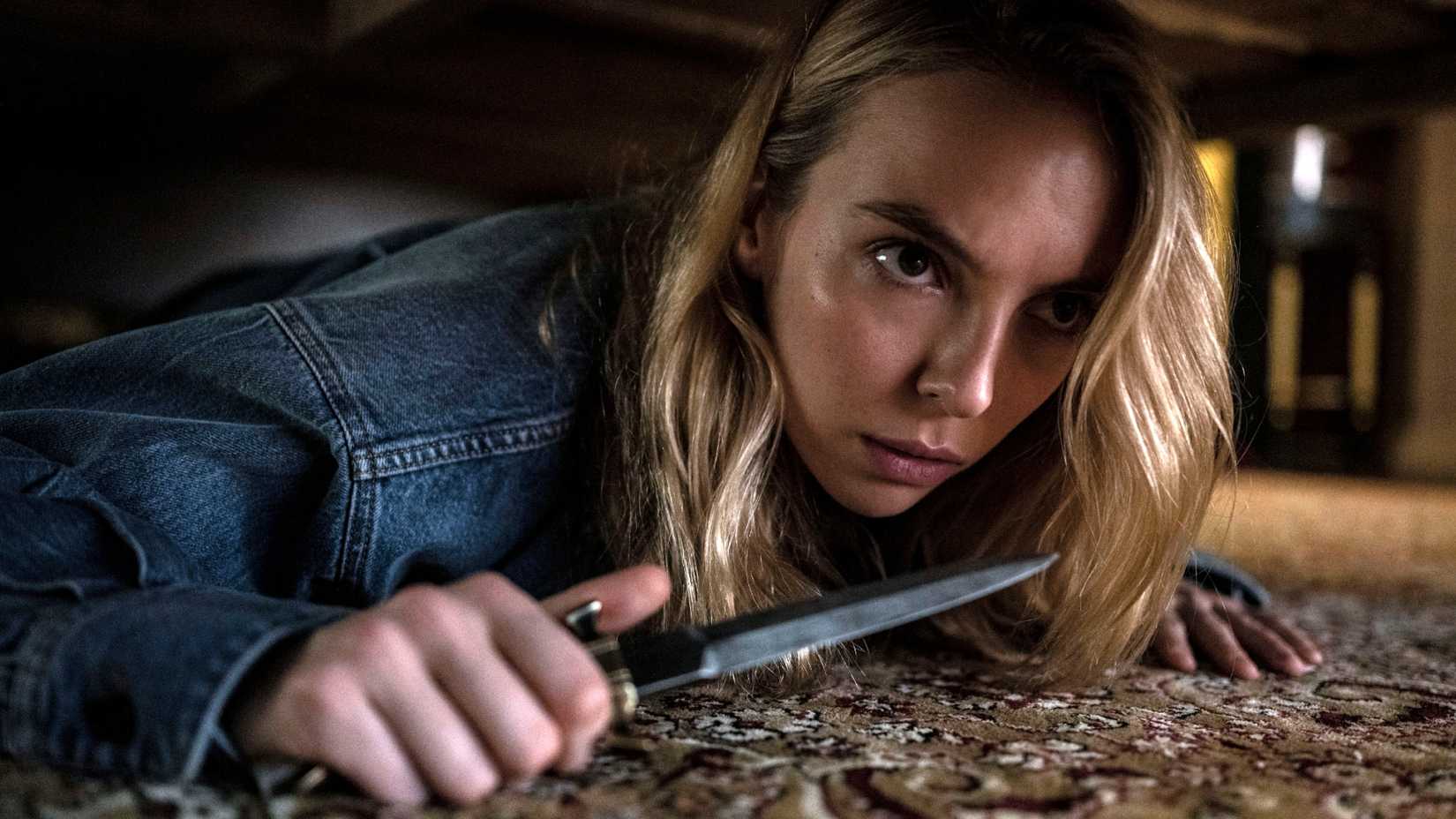 Jodie Comer under a bed with a knife in Killing Eve