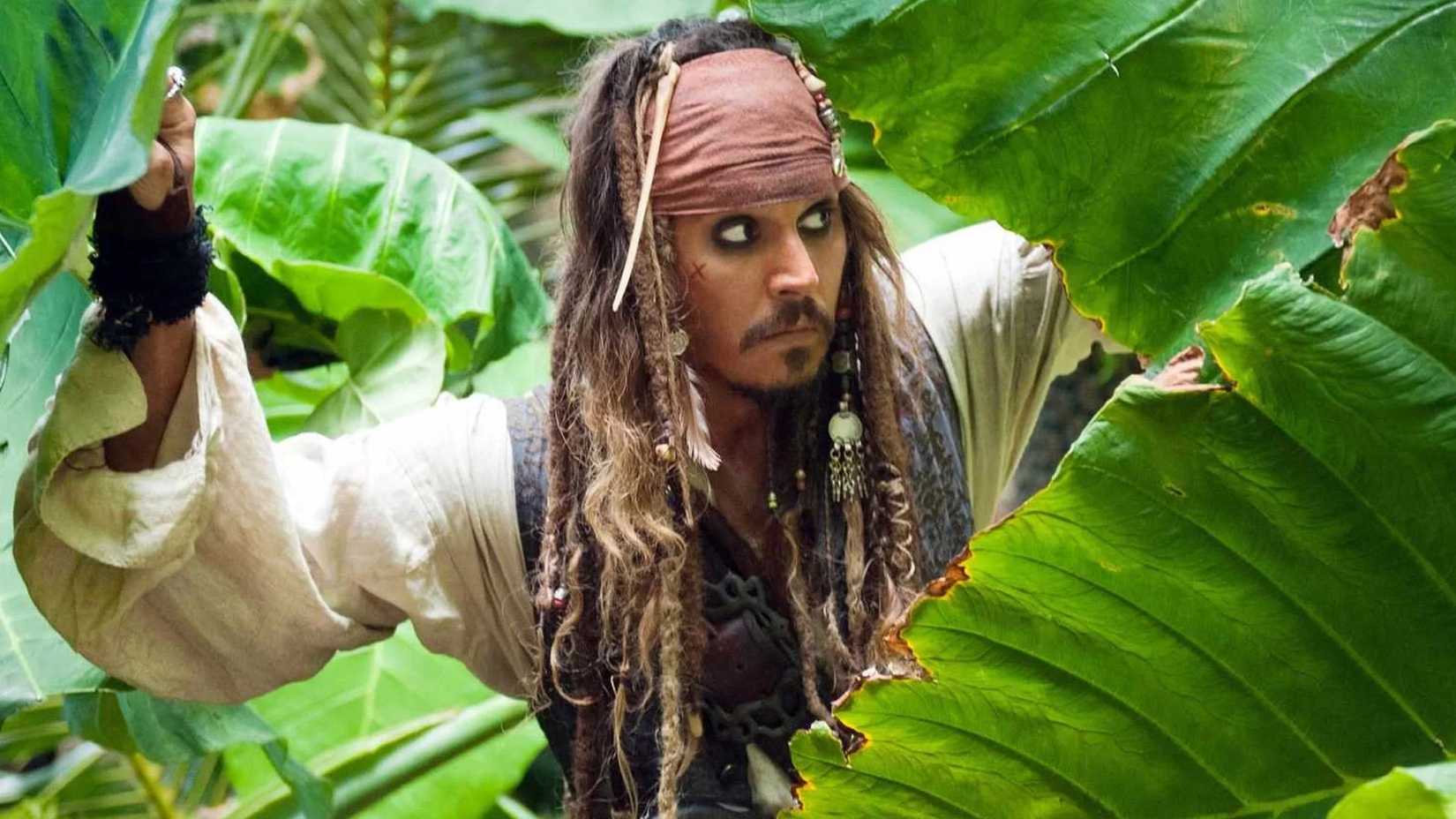 Johnny Depp as Jack Sparrow peeking through greenery in the jungle