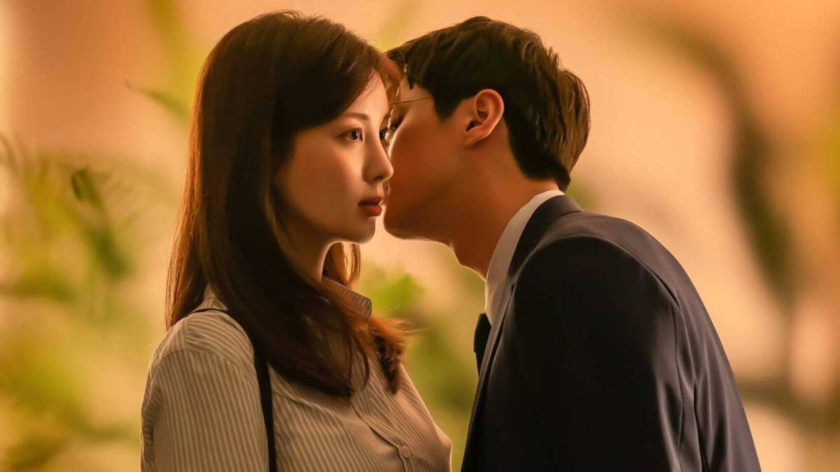 Un hombre susurra en el oído de una mujer en la película coreana Love and Leashes.