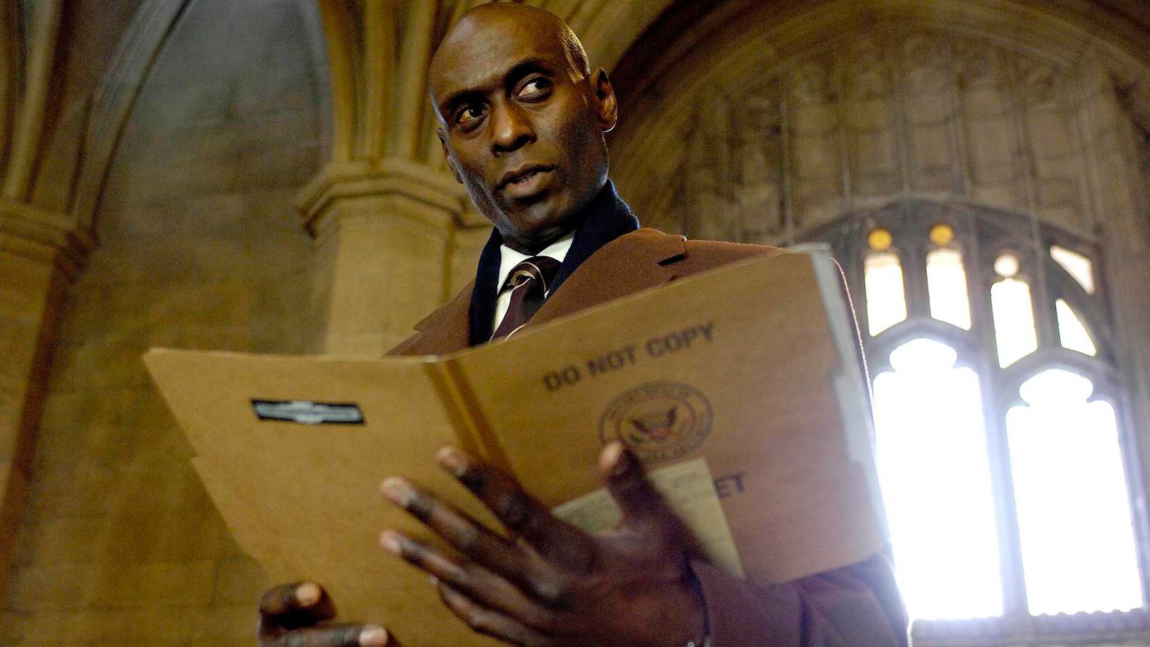 Lance Reddick's Broyles looking suspicious while holding a file folder in Fringe