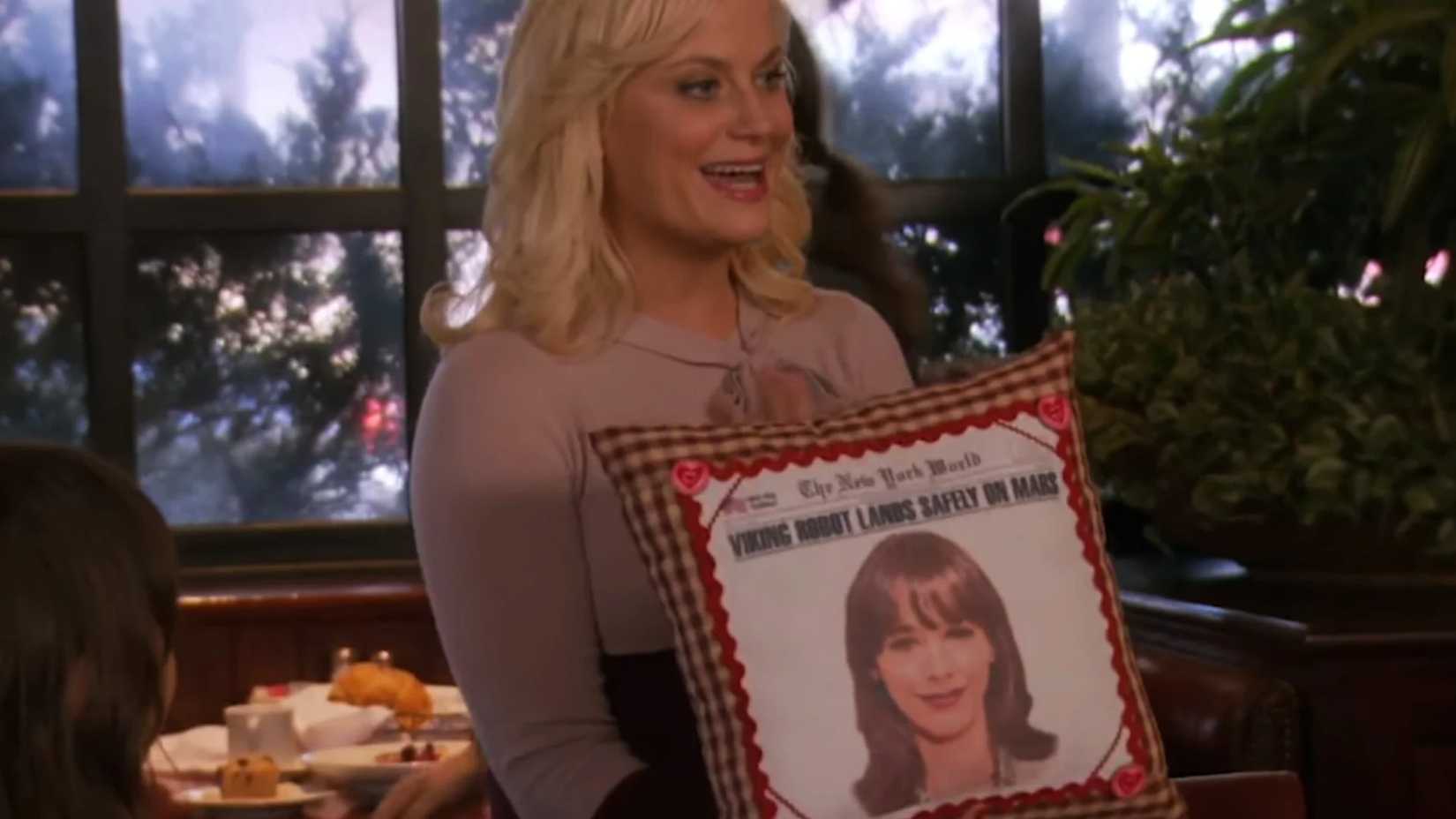 Leslie Knope in Parks and Rec hält am Galentine-Tag ein Kissen hoch