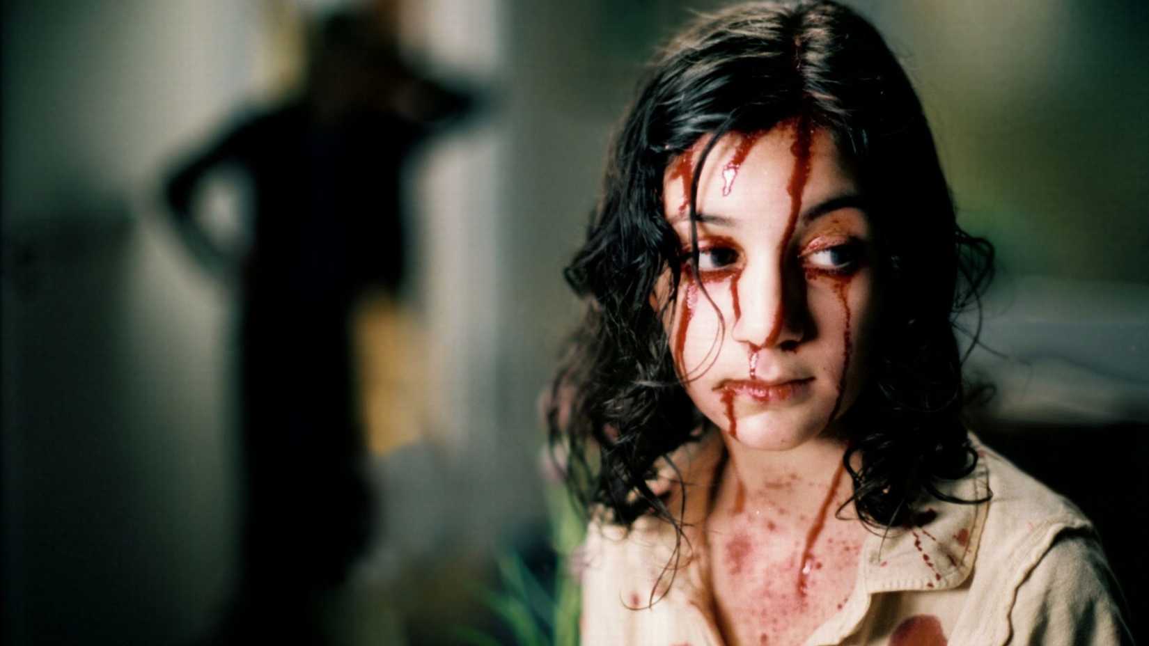 Lina Leandersson como Eli coberta de sangue em Deixa Ela Entrar
