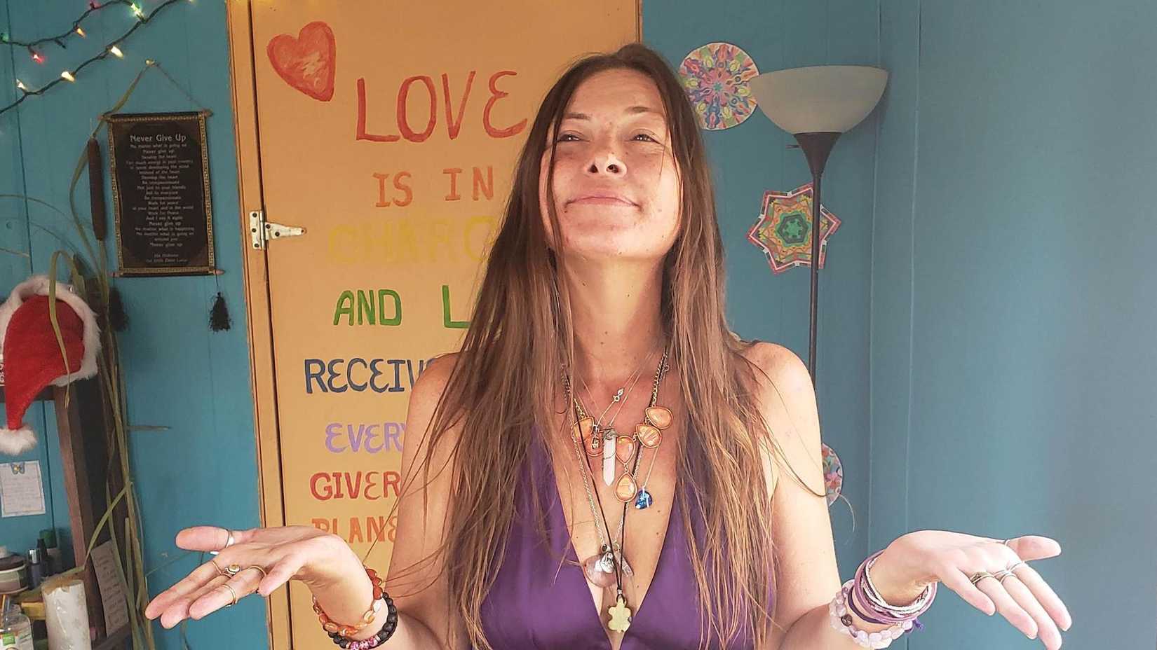 Mulher com as palmas das mãos abertas em frente a uma porta com a palavra 