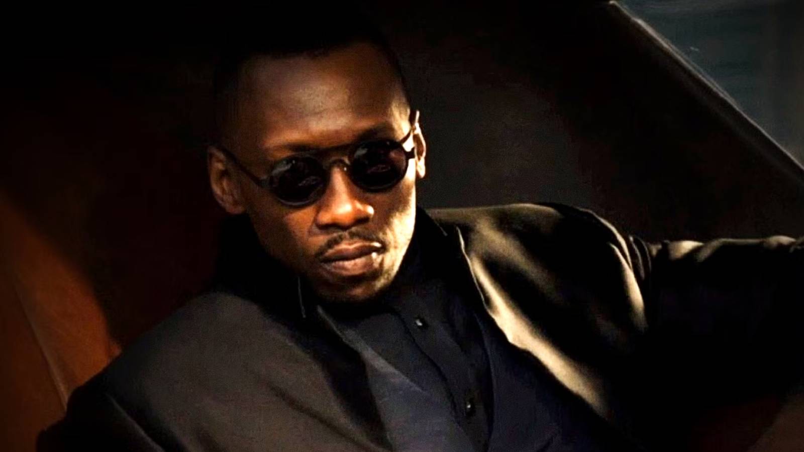 Mahershala Ali's Vector steps out of a car wearing sunglasses in Alita Battle Angel