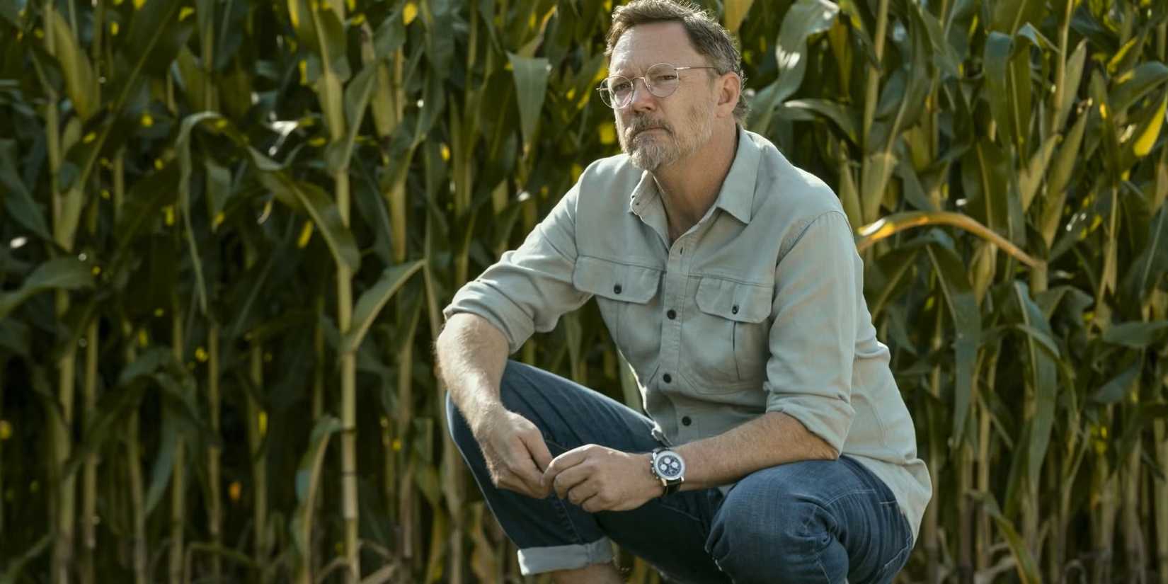 matthew lillard crouches down in a field of corn in cross season 2
