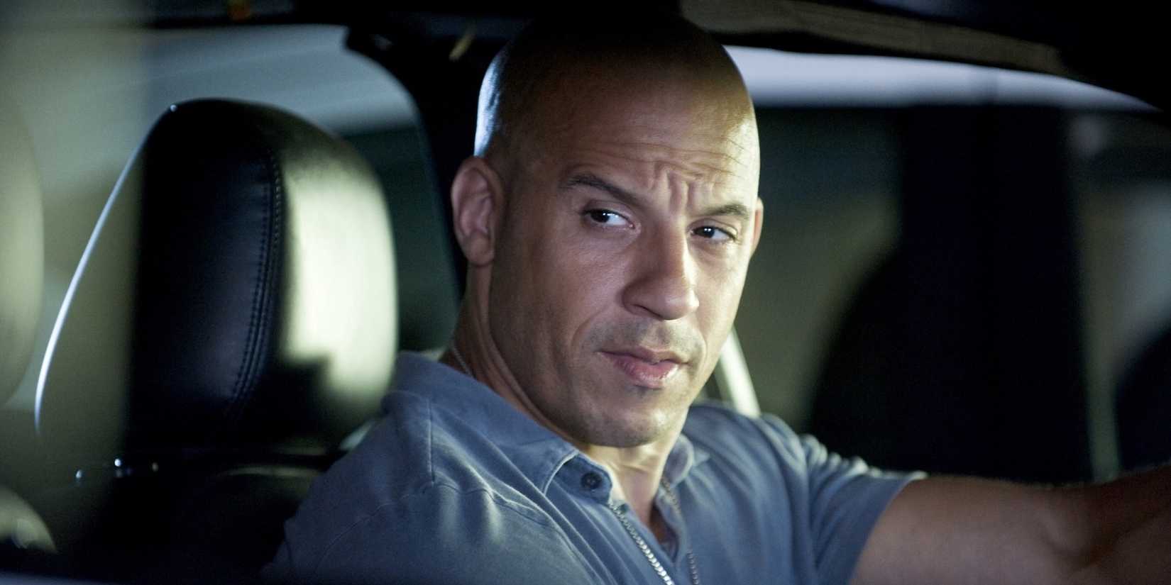Vin Diesel as Dominic Toretto in a car looking out the window in Fast Five.