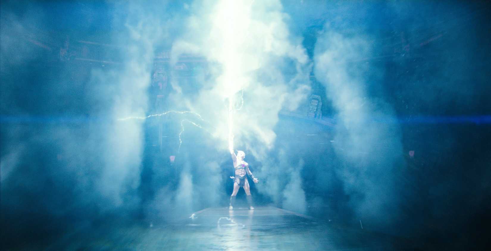 Nicholas Galitzine as He-Man, thrusting the sword into the air as light and smoke emit from it in Master of the Universe 2026