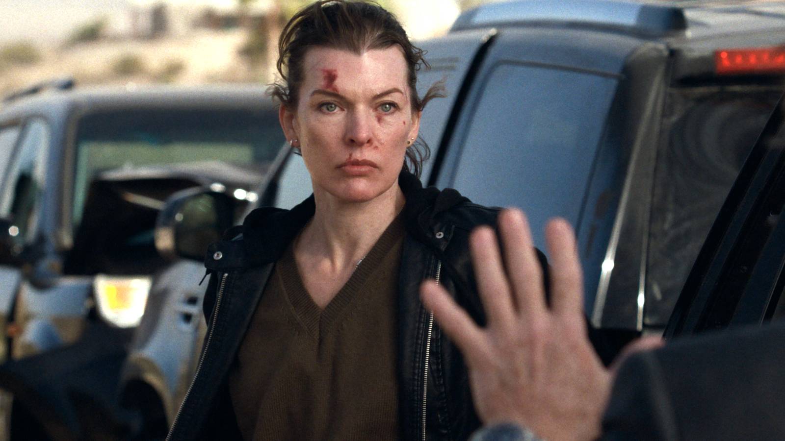 Milla Jovovich's Nikki looking angrily at someone standing next to a truck in Protector