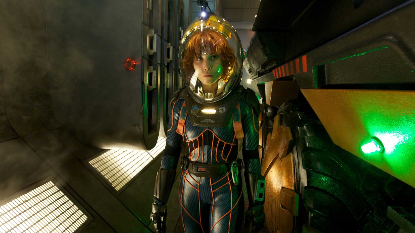 Noomi Rapace as Elizabeth Shaw wearing a space suit walking toward the camera in Prometheus