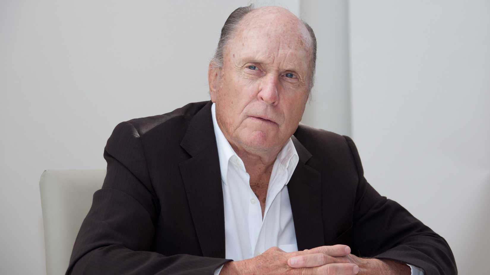 Robert Duvall looks on seriously in a press conference 