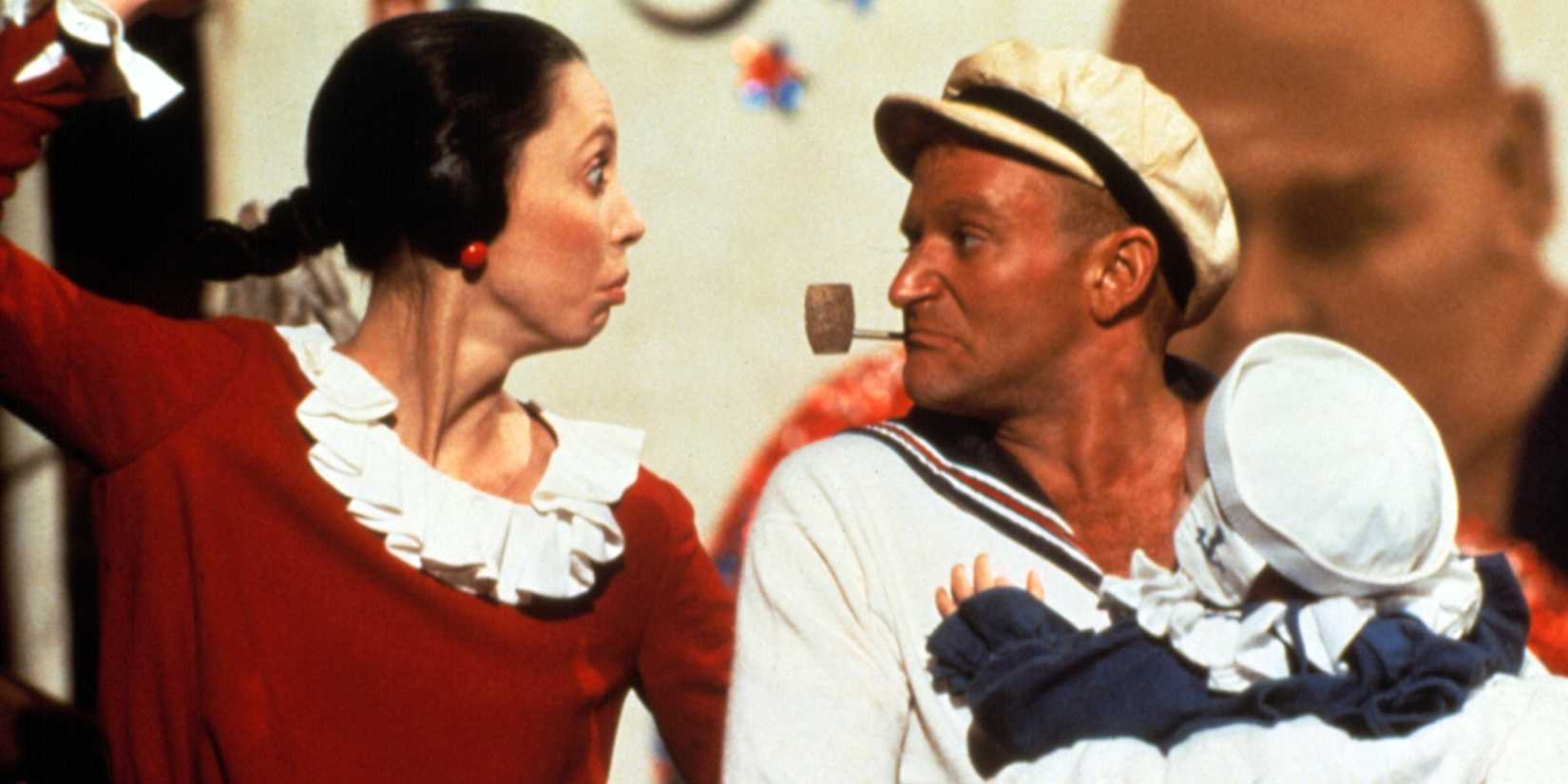 Robin Williams hält ein Baby und Shelley Duvall sieht in Popeye verrückt aus