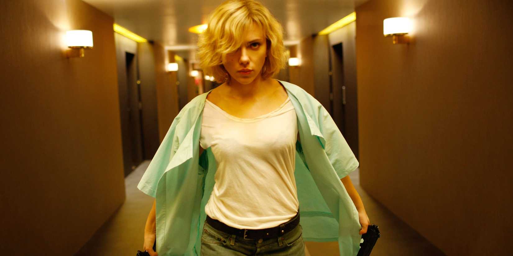 Scarlett Johansson with guns in a hotel hallway in Lucy