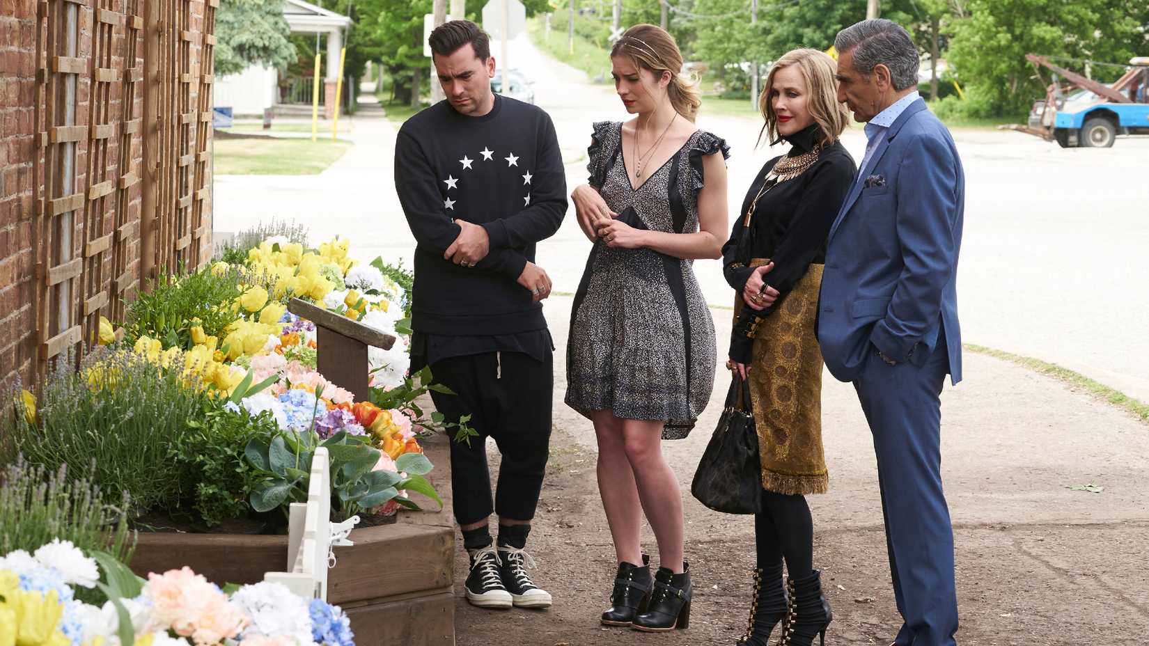 Os Roses olhando para um canteiro de flores em Schitt's Creek