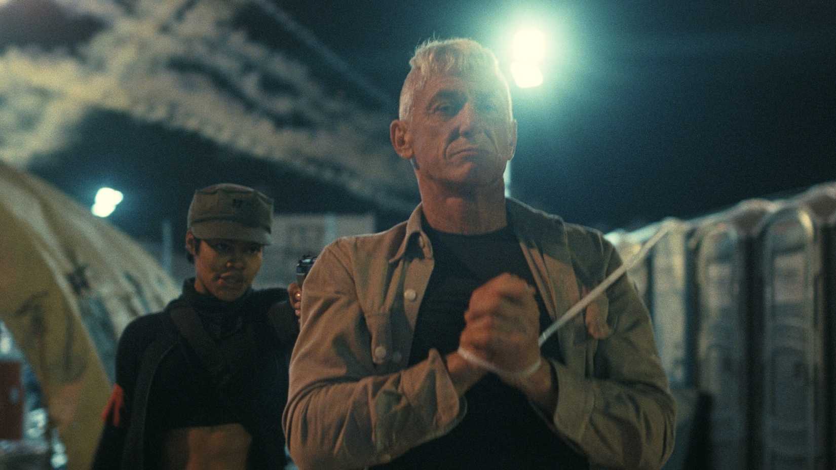 Sean Penn as Lockjaw with Perfidia pointing a gun at him in One Battle After Another