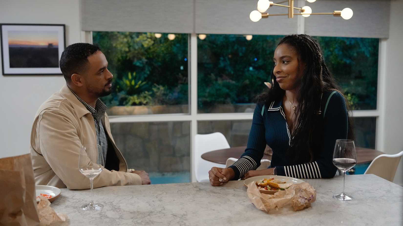 Gaby and Derek sitting in a kitchen in Shrinking