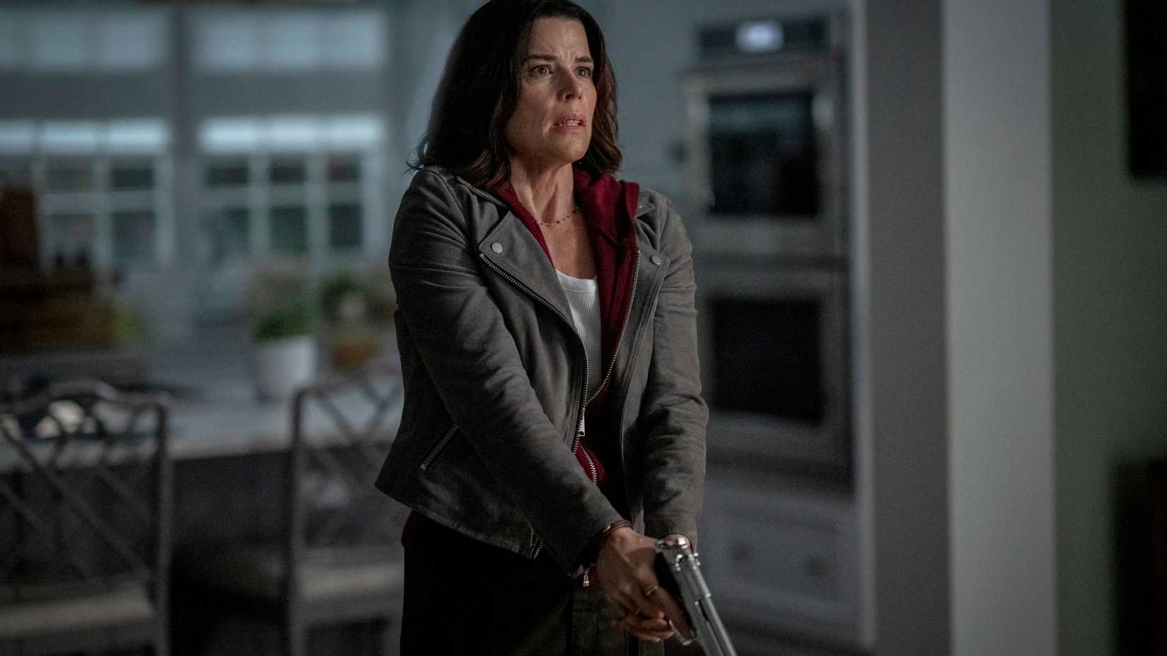 sidney holding a gun pointed at the floor in scream 7