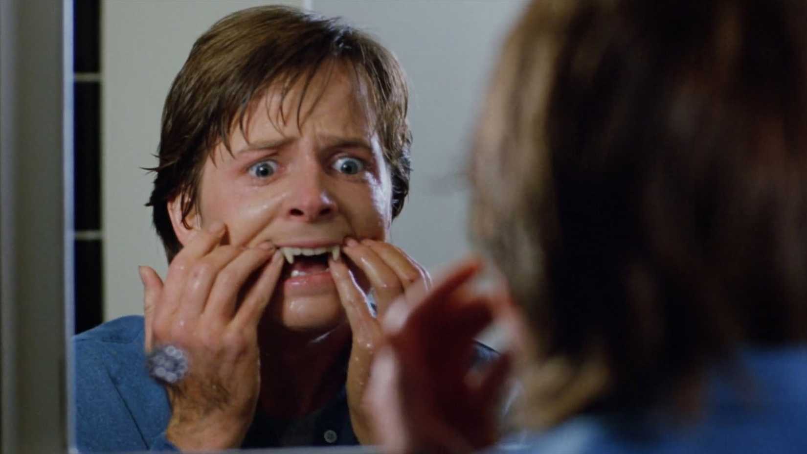 Michael J. Fox looks at himself in the mirror as his fangs grow in Teen Wolf