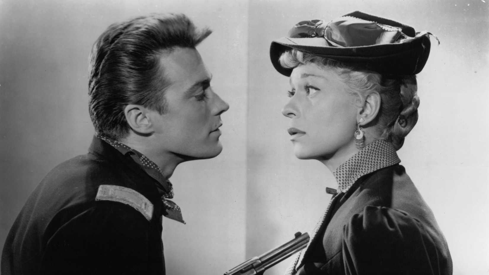 Клинт Эстоуд направляет пистолет на Джинджер Роджерс в промо-изображении для «Первой путешествующей продавщицы»