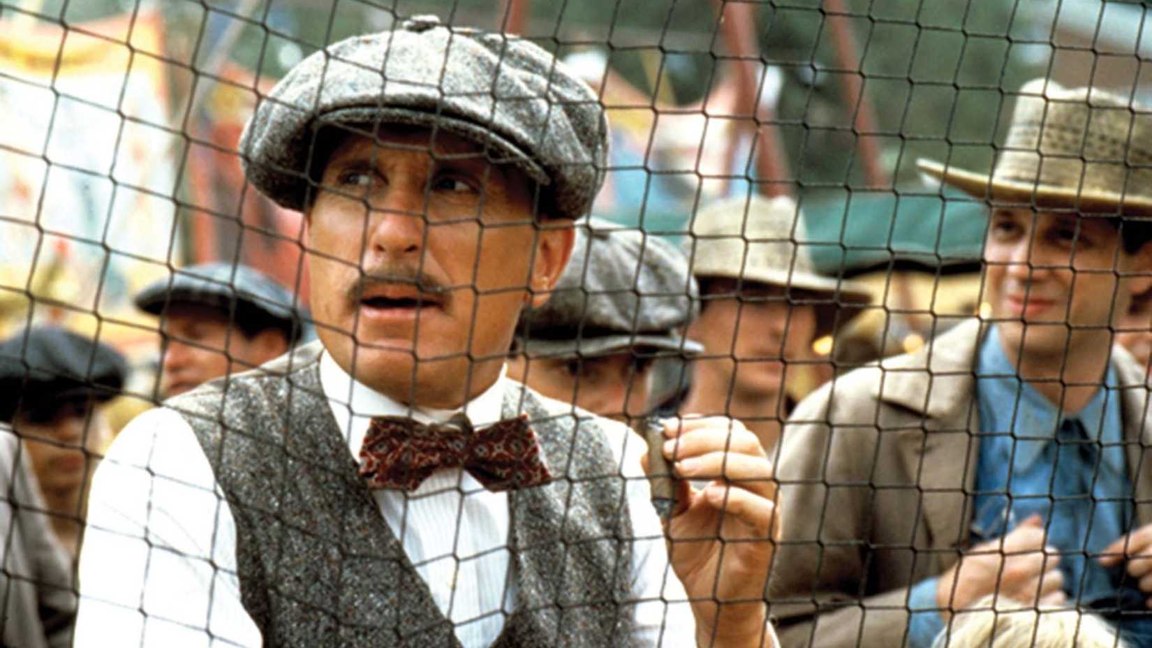 Robert Duvall holds a cigar while watching baseball in The Natural
