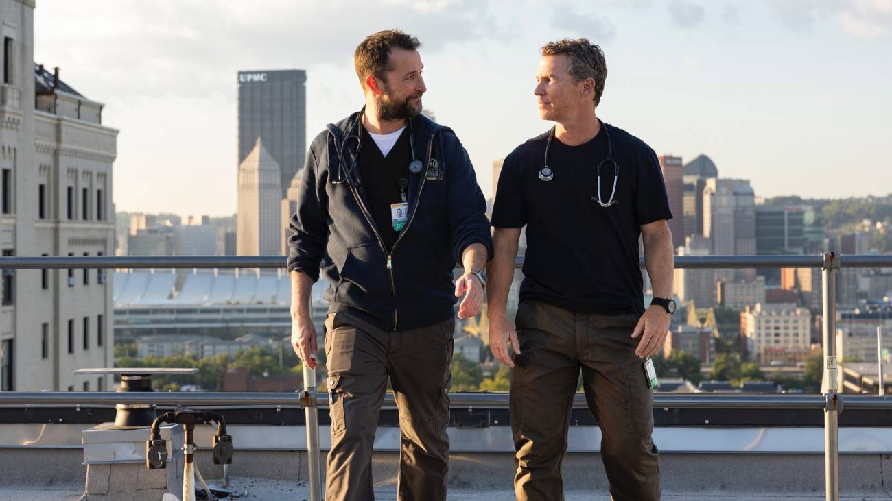 Shawn Hatosy as Jack Abbot and Noah Wyle as Michael "Robby" Robinavitch in The Pitt Season 1.