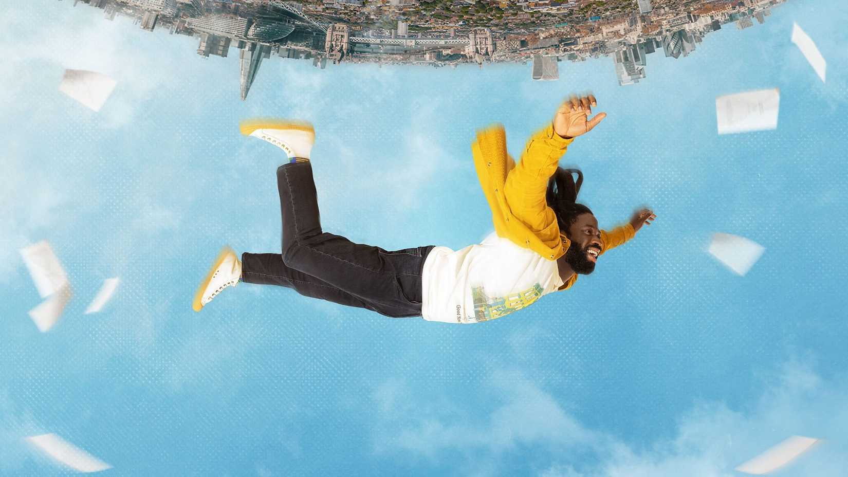 Pôster de Dreaming Whilst Black com um homem sorrindo caindo do céu.