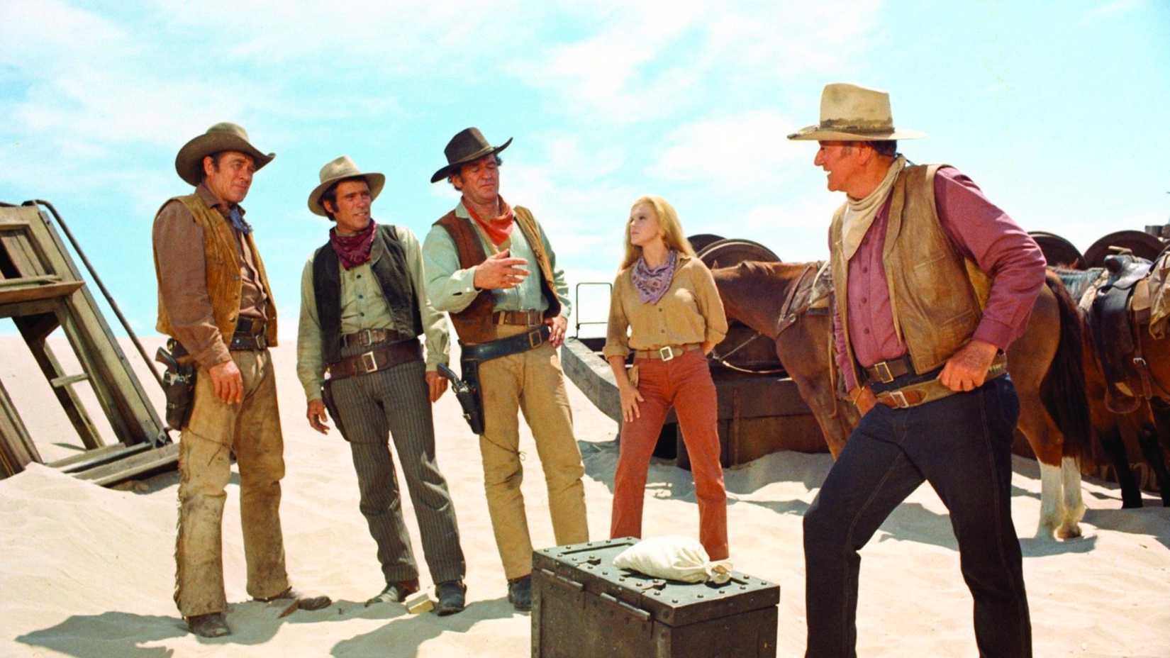 O elenco conversa no deserto em The Train Robbers