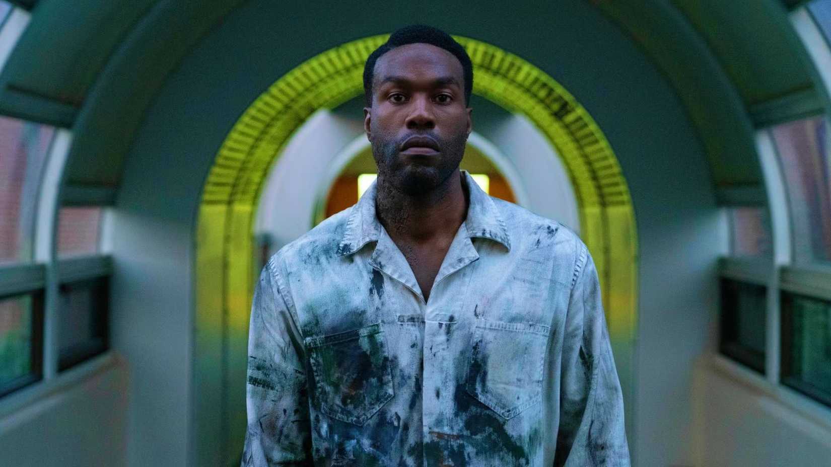yahya abdul mateen ii as anthony looking intense underneath a yellow arch in candyman 2021