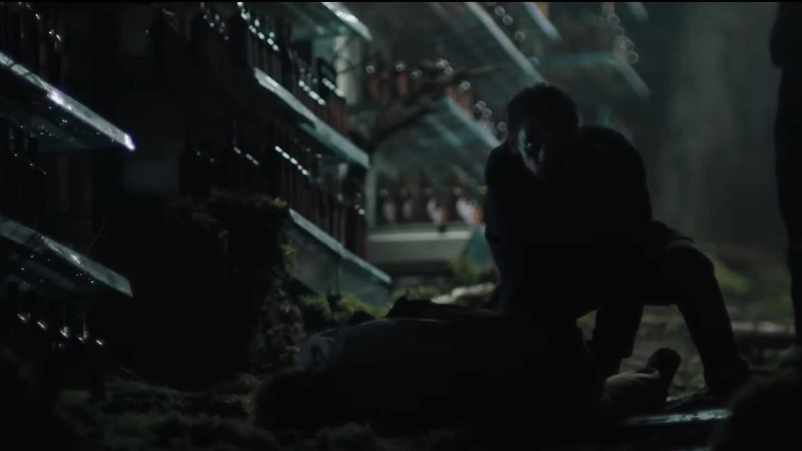 Um homem nas sombras em pé sobre um cadáver em uma sequência de sonho em The Ritual