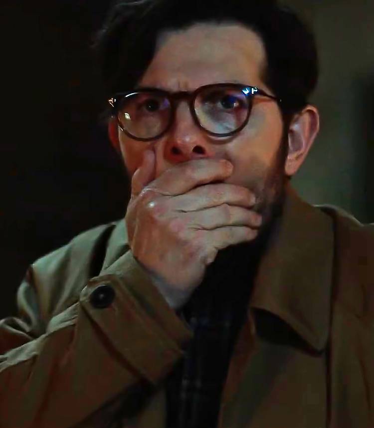 Adam Scott como Ohm em Hokum, com a mão sobre a boca em choque.