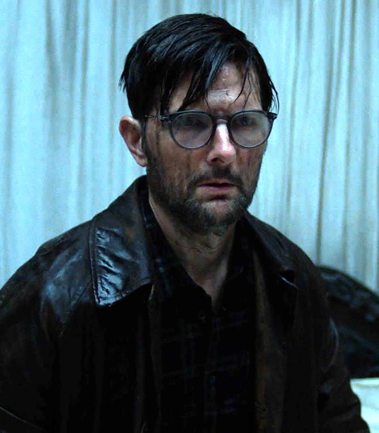 Adam Scott como Ohm em Hokum, com o rosto preocupado e coberto de água.