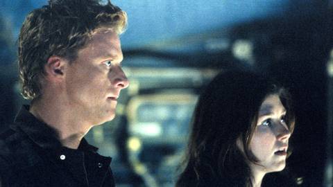 Wash (Alan Tudyk) and Kaylee (Jewel Staite) looking at something in Firefly