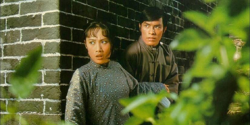 Angela Mao and Carter Wong hide by a wall in Hapkido