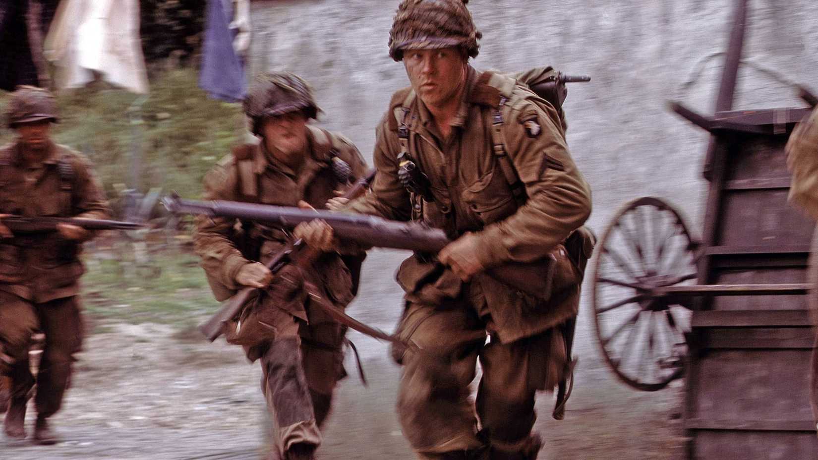 Michael Cudlitz como Denver (Bull) Randleman correndo em uma rua no episódio de Band of Brothers, Replacements.
