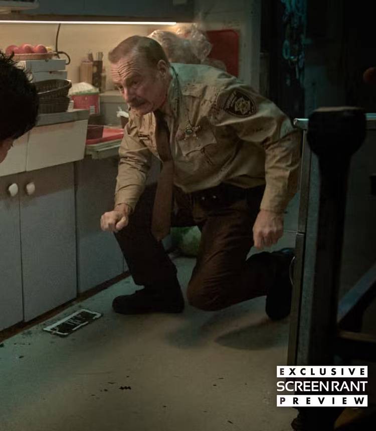 Bob Odenkirk's Ulysses looking worried as someone runs at him with a knife in a kitchen in Normal
