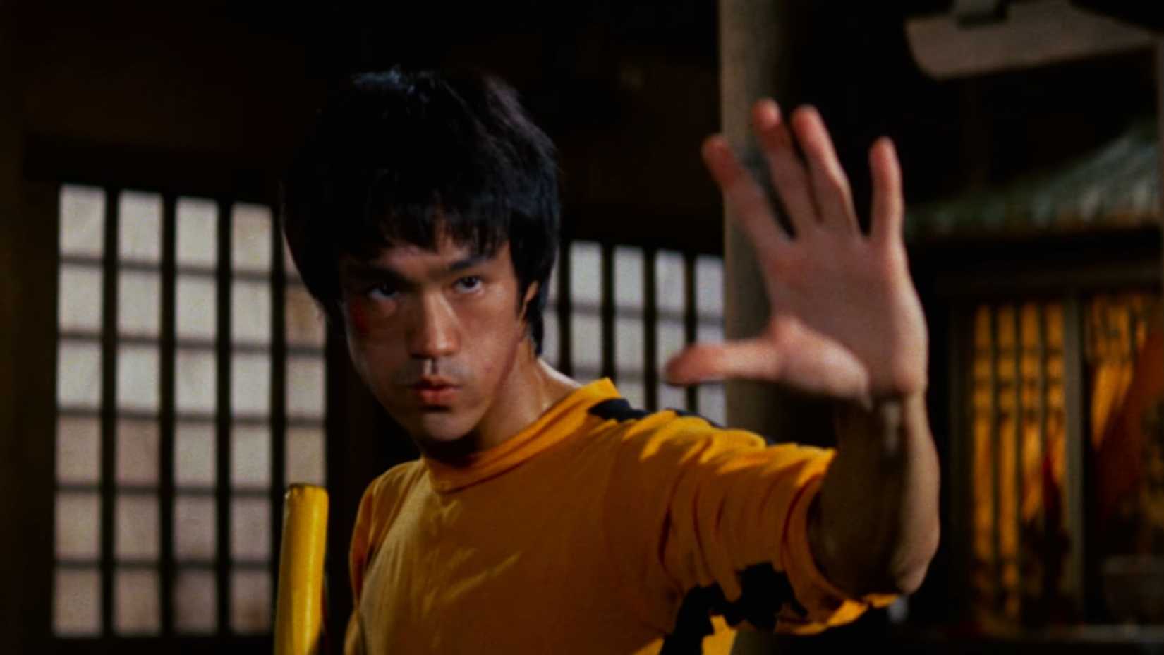 Bruce Lee com nunchakus pronto para lutar contra Pasqual em Jogo da Morte