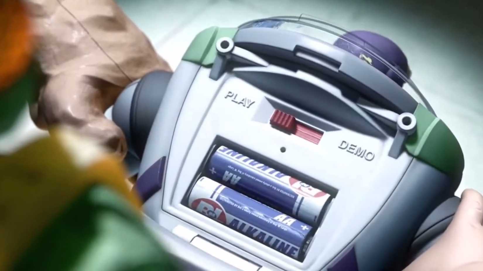 Buzz Lightyear com o painel da bateria aberto sendo reiniciado em Toy Story 3