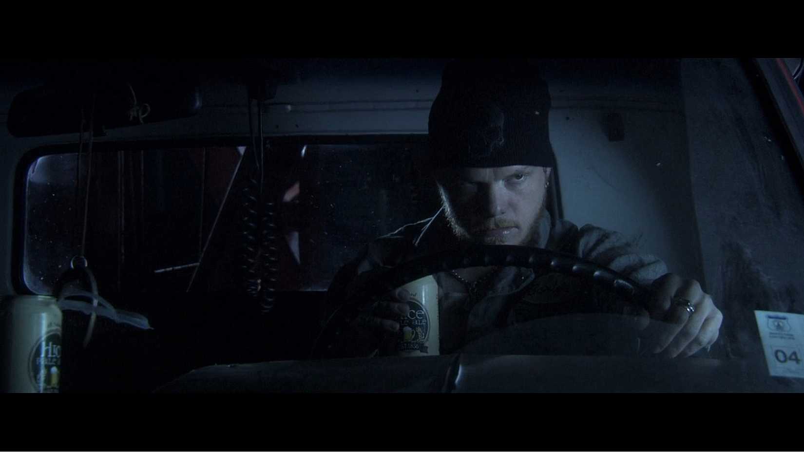 Carter Daniels de Premonição 4 sentado em seu caminhão, segurando uma cerveja