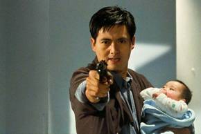 Chow Yun fat as Tequila pointing a gun and holding a baby in Hard Boiled