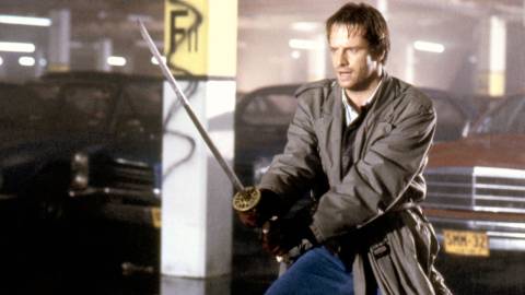 Christopher Lambert as Connor MacLeod holding a sword in Highlander
