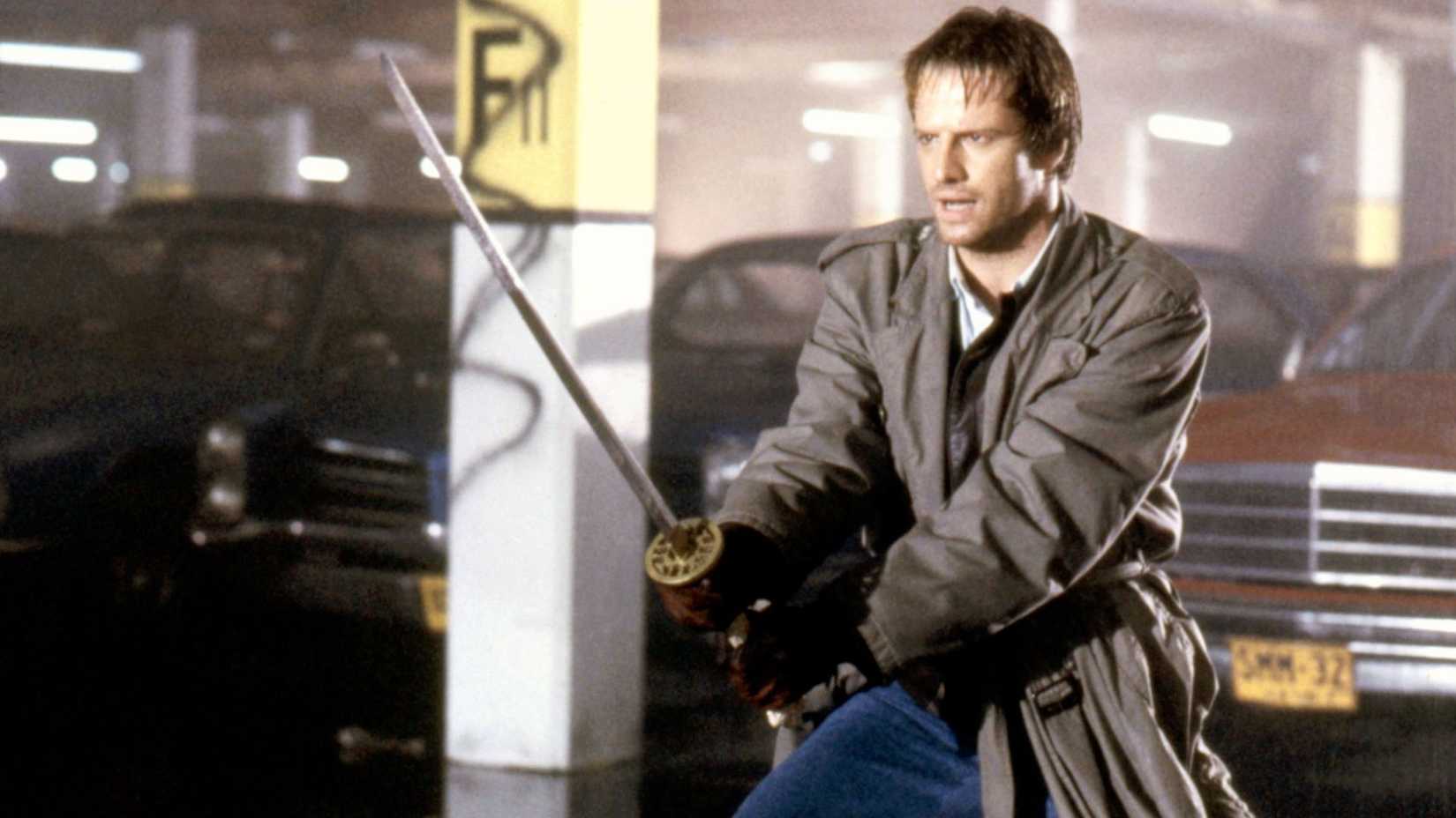 Christopher Lambert as Connor MacLeod holding a sword in Highlander