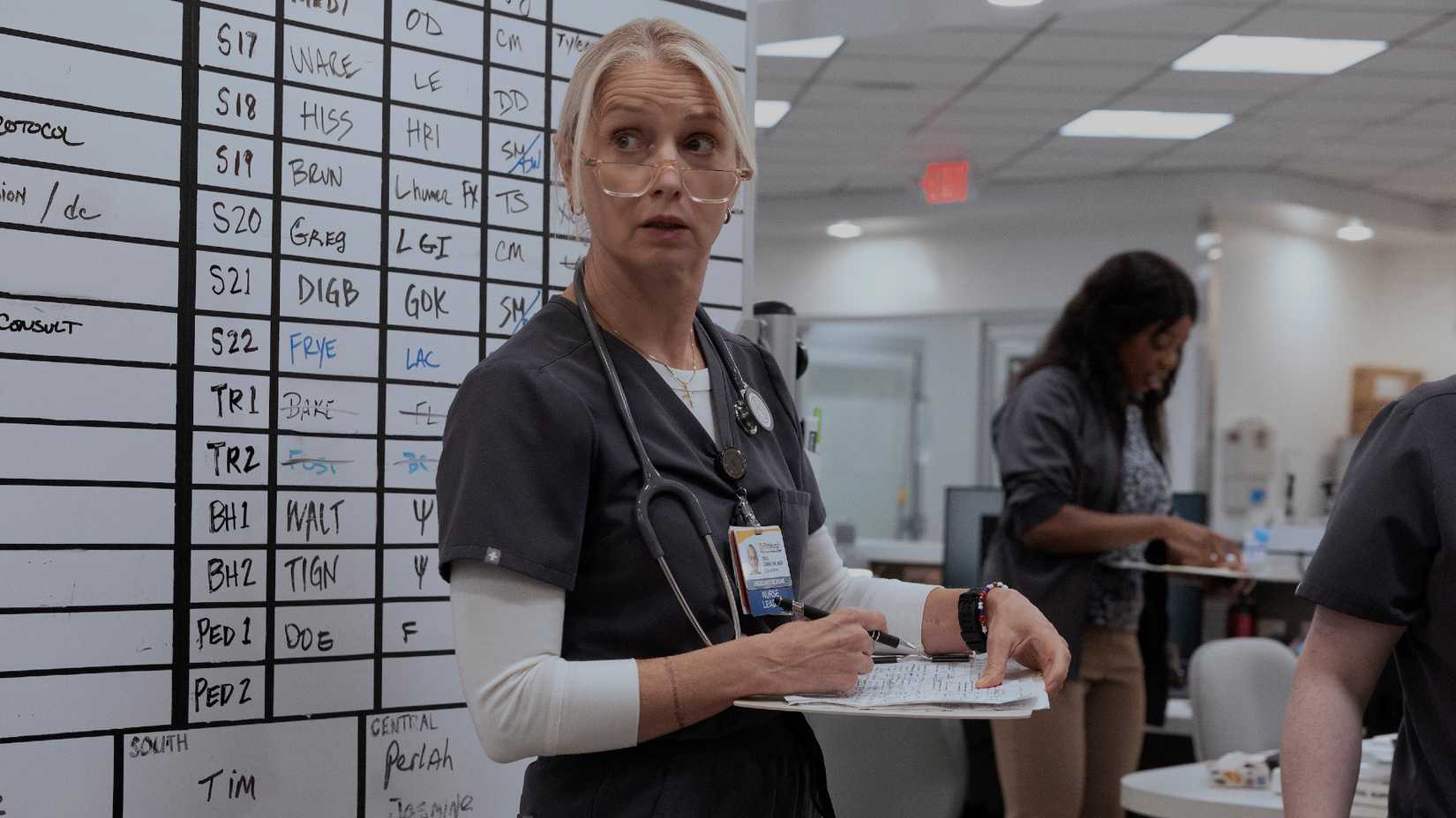 Dana em frente a um prontuário médico com uma prancheta em mãos em The Pitt 2ª temporada