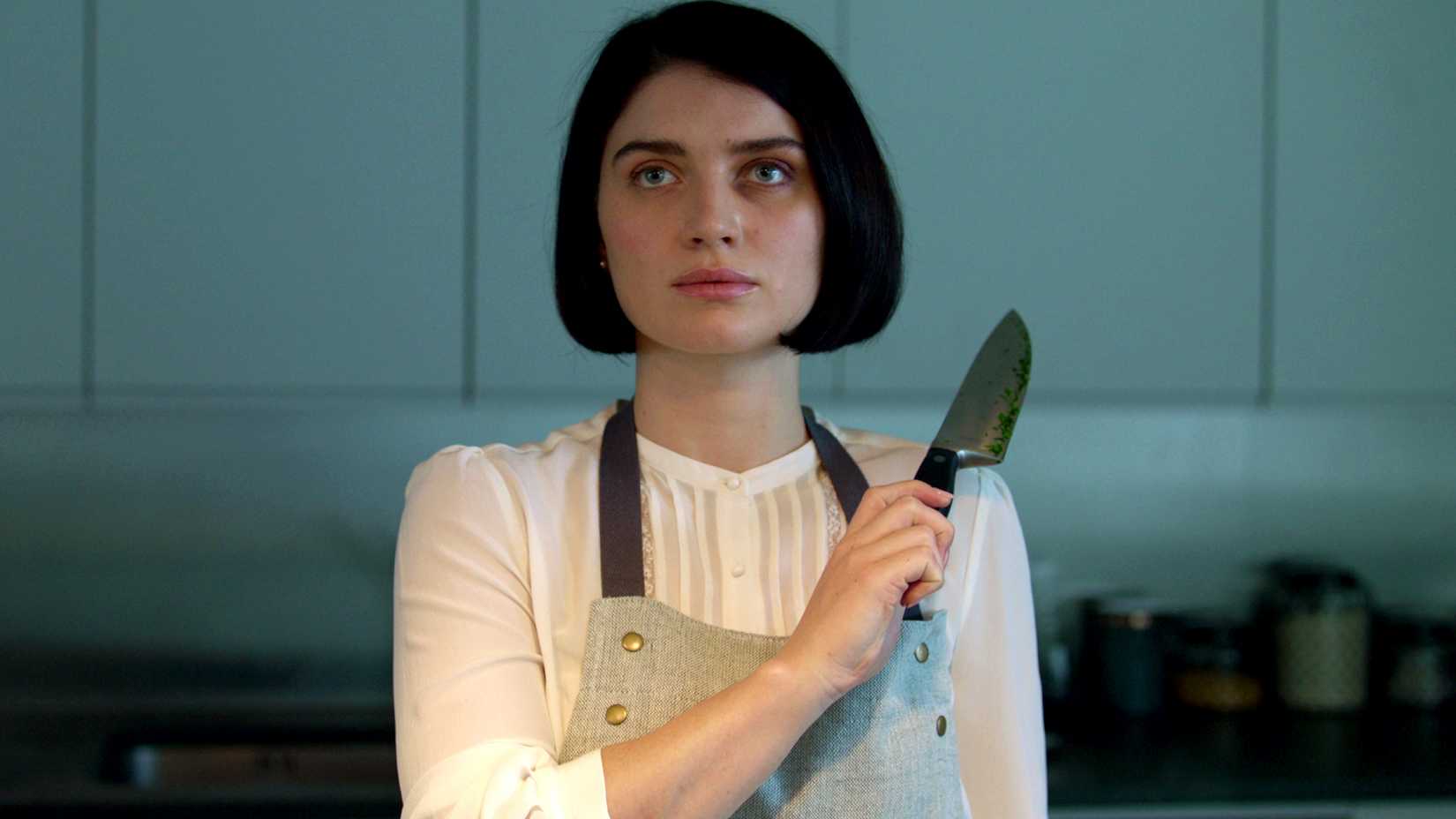 Eve Hewson as Adele Ferguson holding a knife to her shoulder in Behind Her Eyes