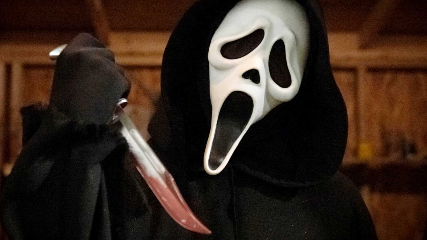 Ghostface holding up a bloody knife in a promotional image for Scream 2022
