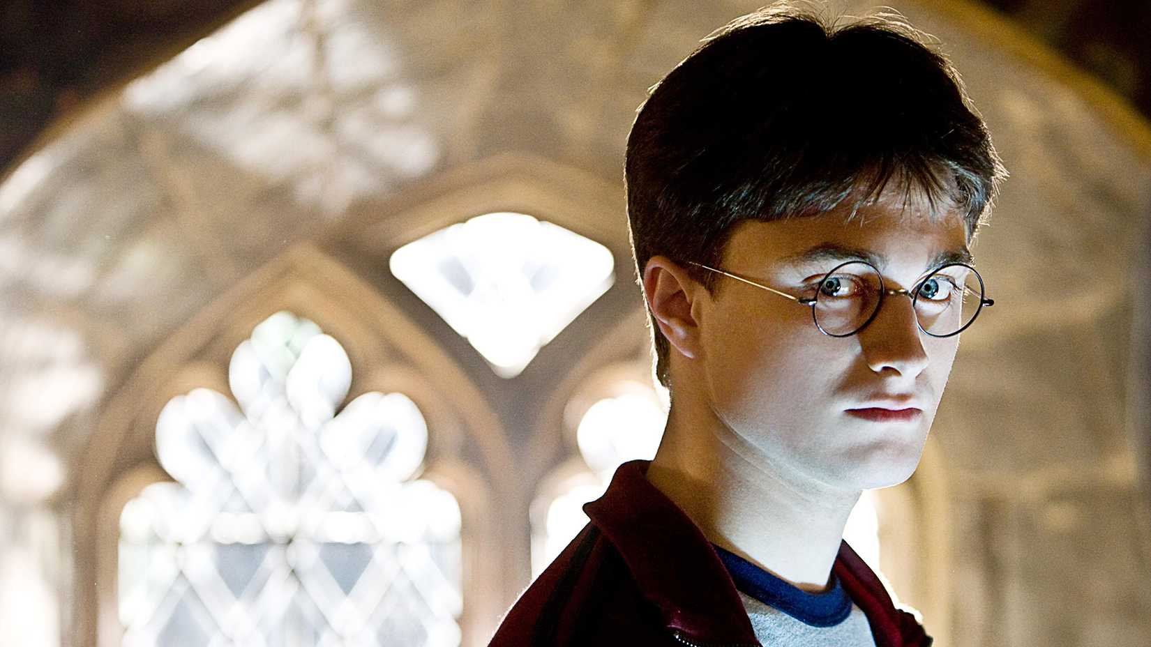 Harry looking serious against a bright window in Harry Potter and the Half-Blood Prince