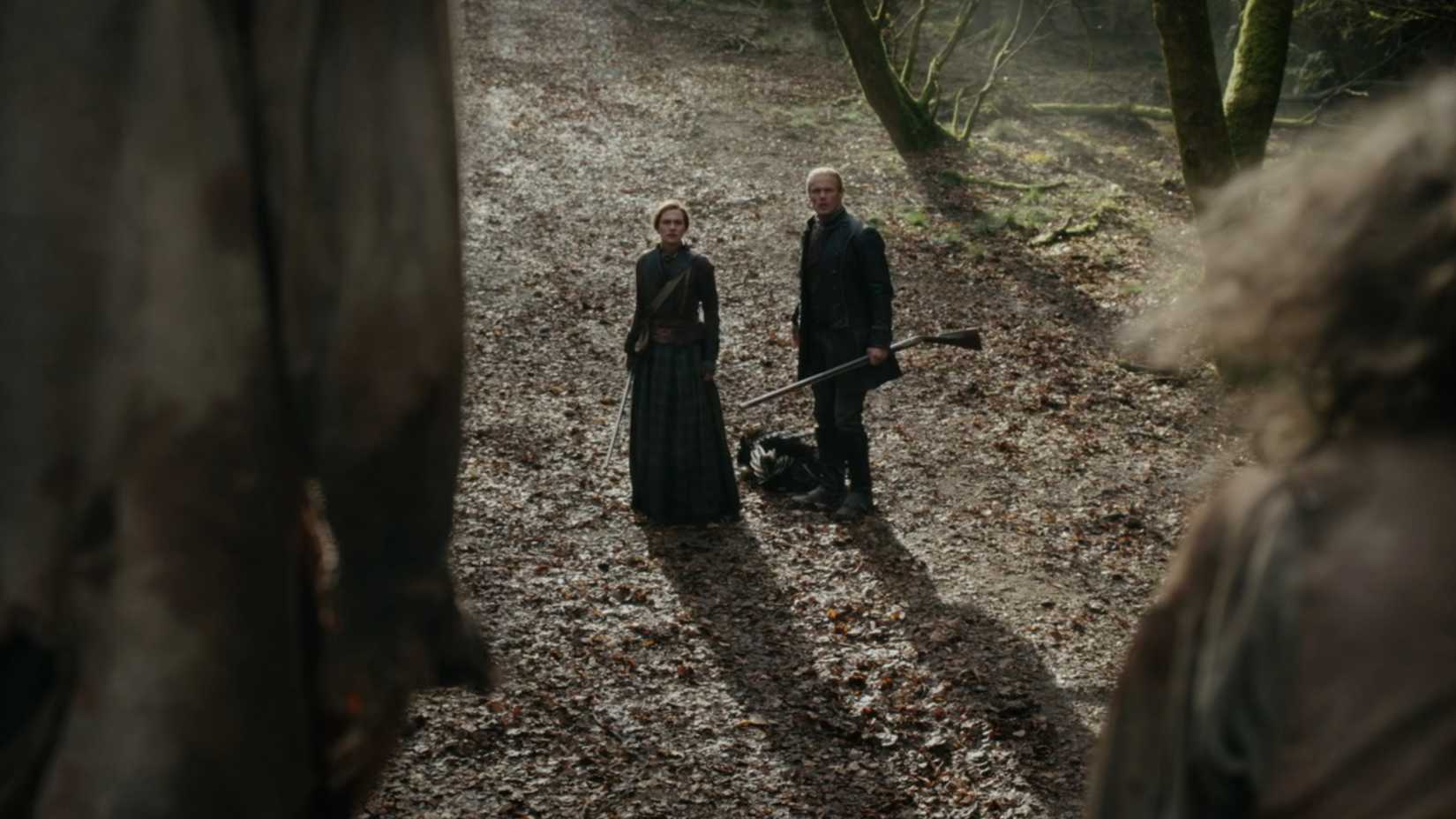 Jamie e Brianna observando dois homens enforcados na temporada 8 de Outlander